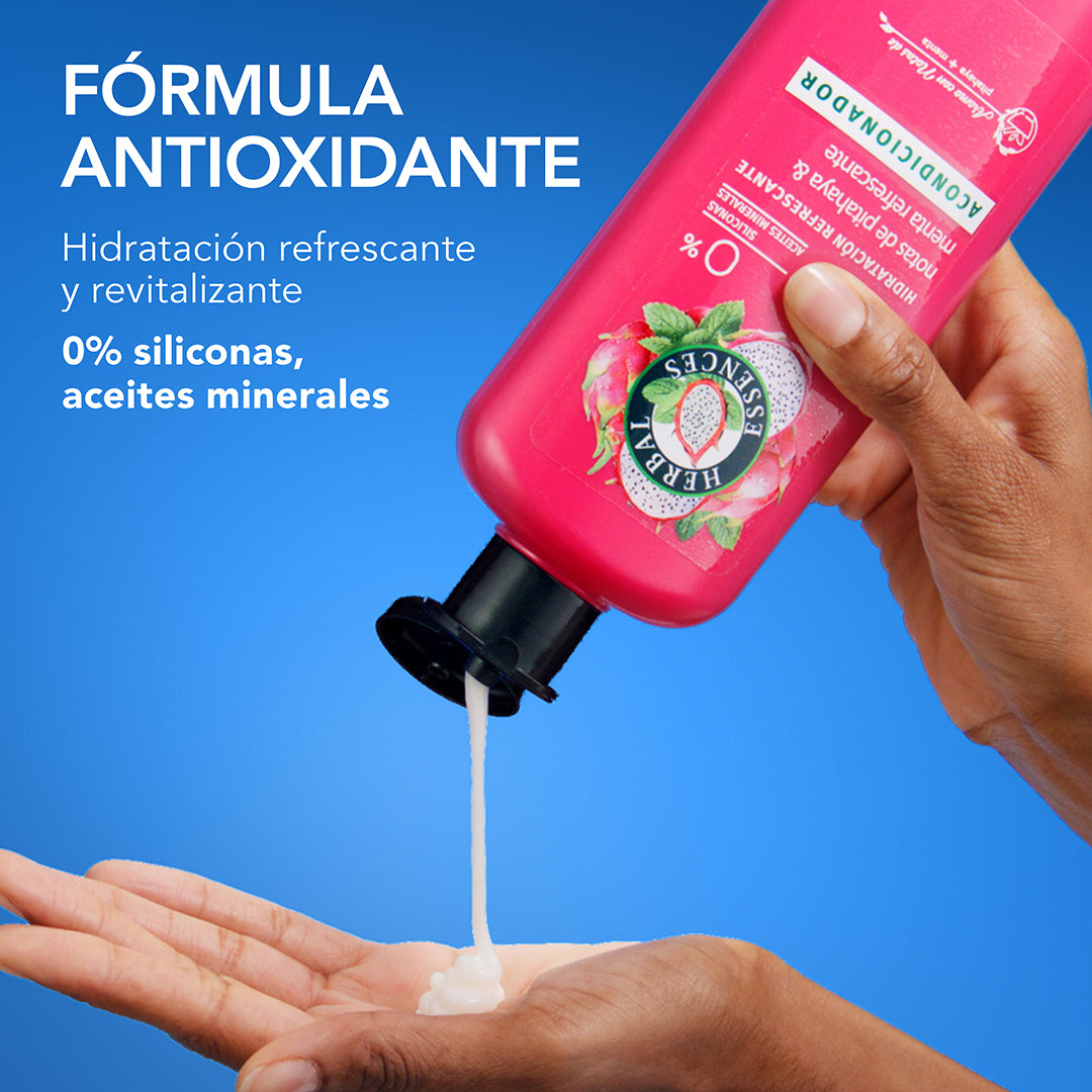 Mano aplicando Acondicionador Herbal Essences Pitahaya y Menta con texto Fórmula Antioxidante hidratación refrescante y revitalizante 0% siliconas y aceites minerales