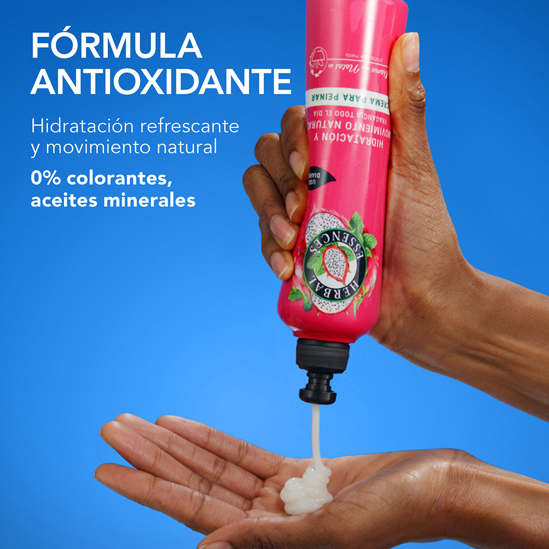 Mano aplicando Crema para Peinar Herbal Essences Pitahaya y Menta con texto Fórmula Antioxidante hidratación refrescante y movimiento natural 0% colorantes y aceites minerales