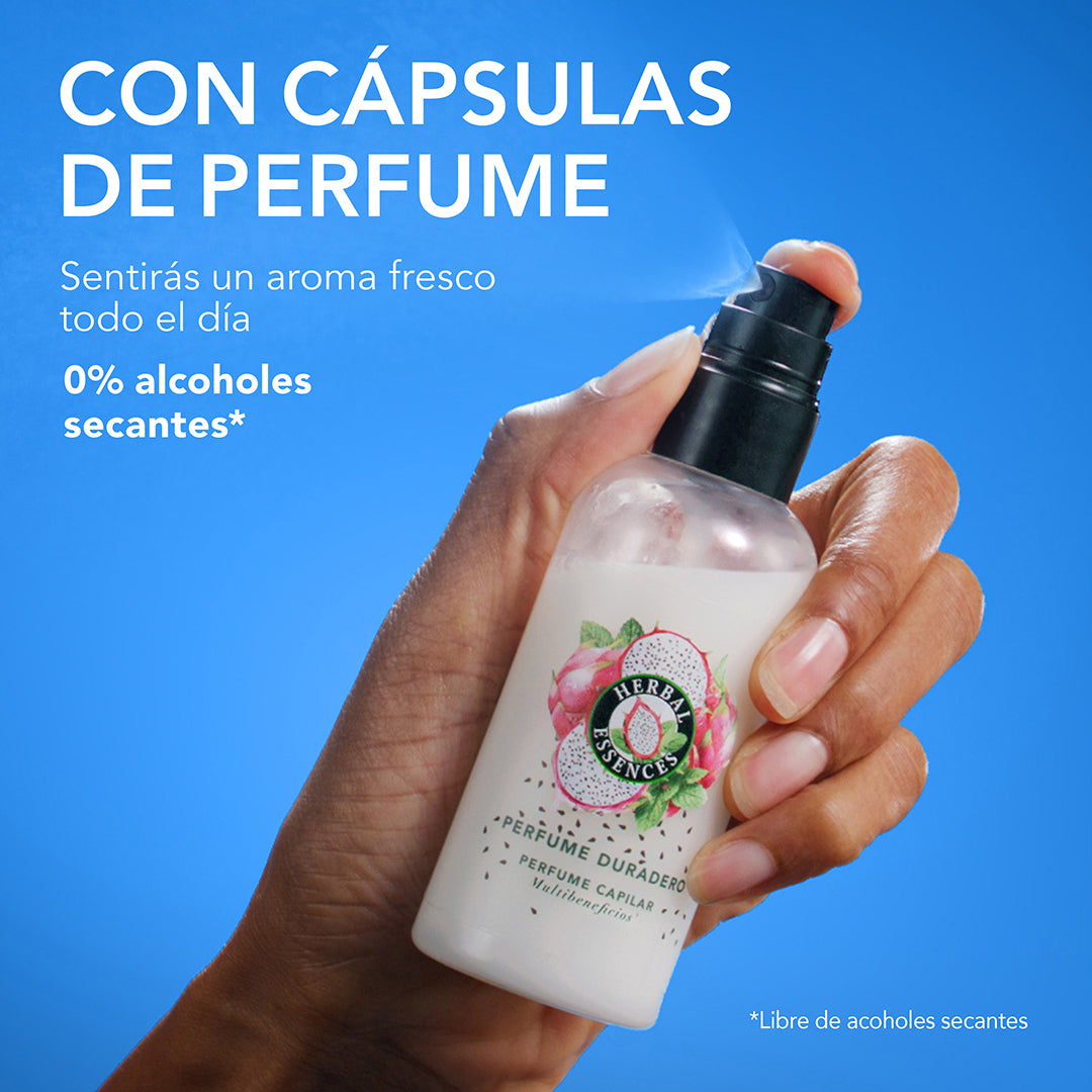 Mano presionando spray de Perfume Capilar Herbal Essences Pitahaya y Menta con texto Con Cápsulas de Perfume aroma fresco todo el día 0% alcoholes secantes