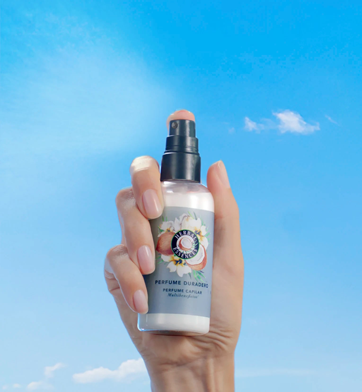 Una mano sosteniendo el Perfume Capilar Duradero con notas de coco