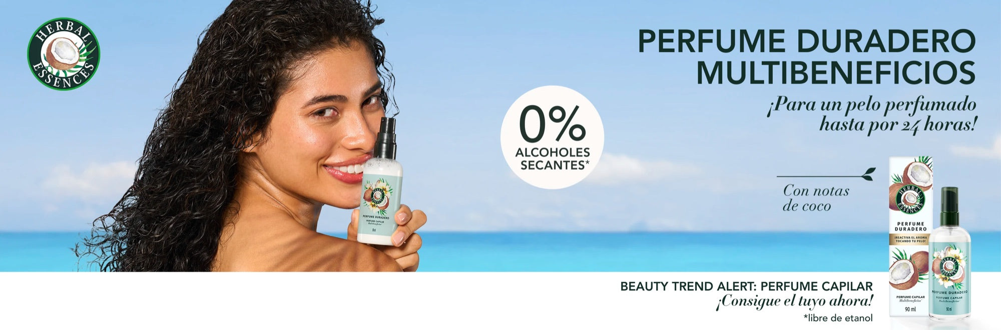 Mujer con cabello crespo en la playa sosteniendo el Perfume Capilar Multibeneficios de Herbal Essences