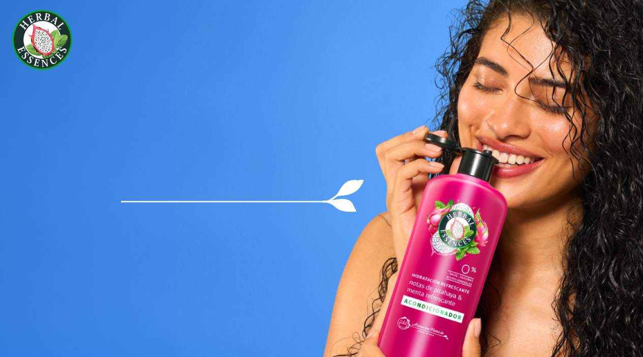 Mujer sosteniendo Acondicionador Herbal Essences Pitahaya y Menta con texto El Complemento Perfecto para un cabello manejable sedoso y vibrante de frescura