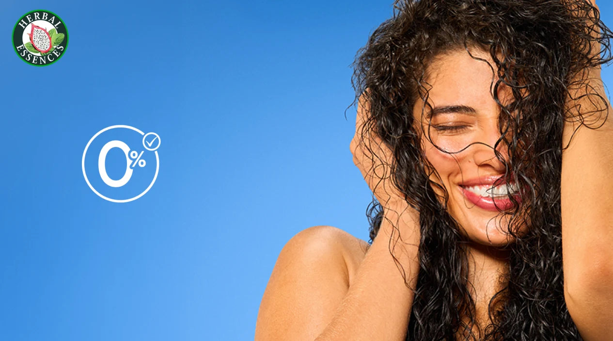 Mujer con cabello rizado y Crema para Peinar Herbal Essences Pitahaya y Menta con texto Movimiento Natural Fórmula Antioxidante 0% Colorantes y Aceites Minerales
